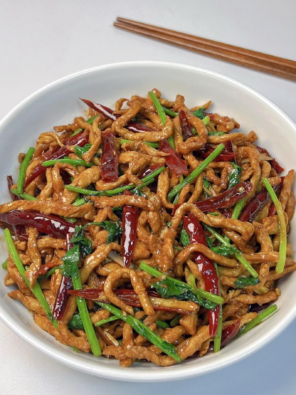 《烧辣椒干丝》这道菜巧妙融合烧辣椒的烟熏香气与干丝的柔韧口感，带来层次丰富的味觉体验